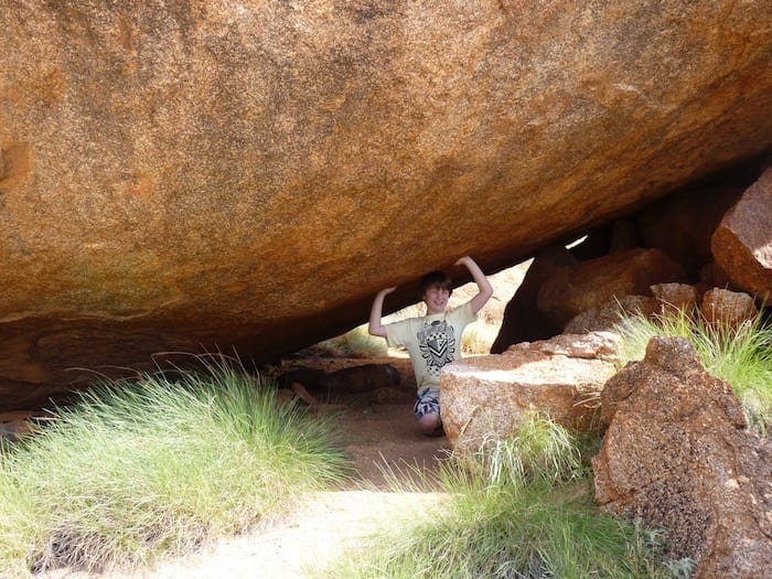 Ben holding up a giant boulder. Devils Marbles.