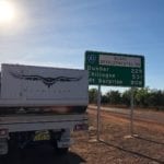 Truck camper beside road sign at start of BDR. Burke Developmental Road Conditions.