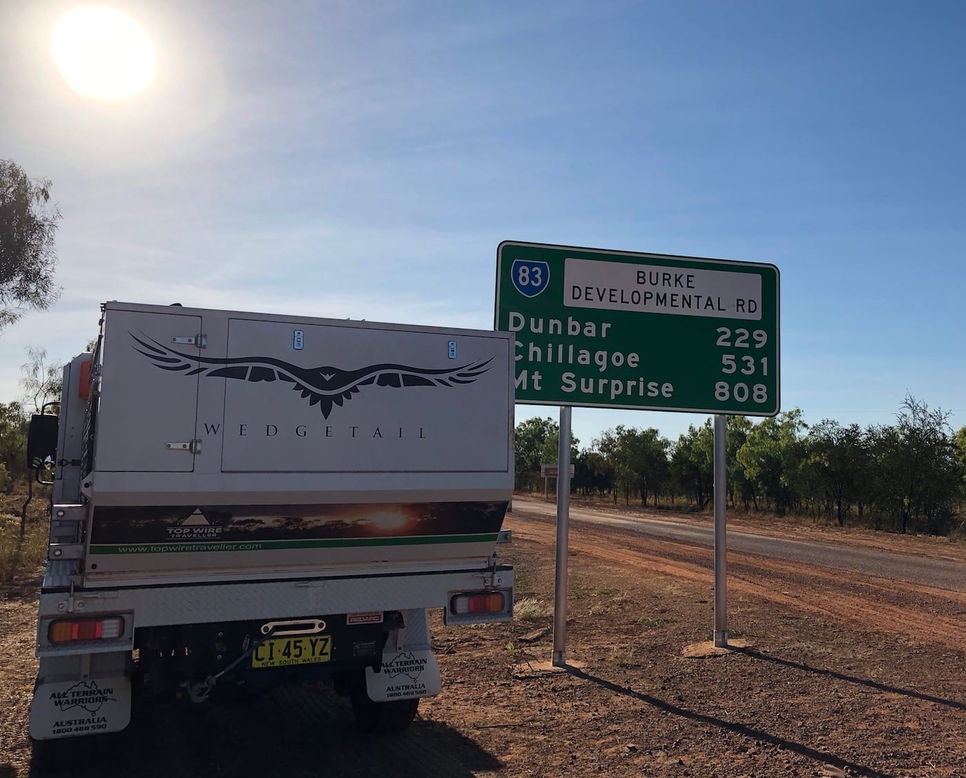 Truck camper beside road sign at start of BDR. Burke Developmental Road Conditions.