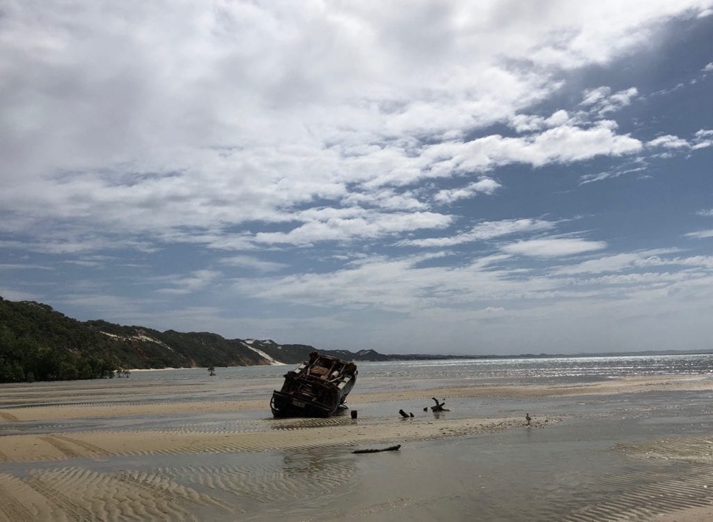 A wrecked 4WD on the beach at the coloured sands. Eddies Camp.