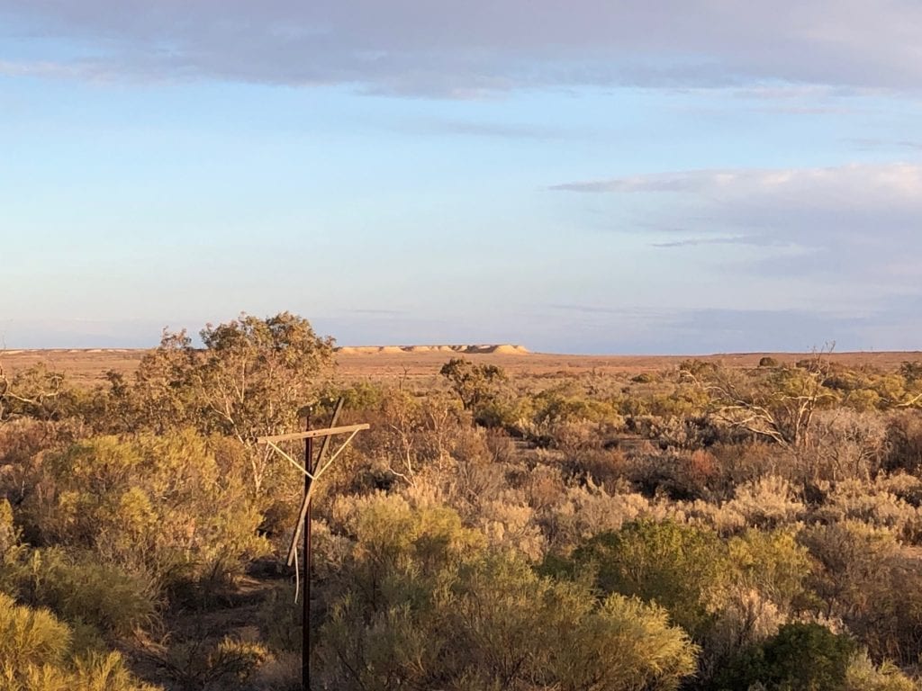 At Gregory Creek, taken from Old Ghan rail bridge. Overland Telegraph Line in foreground, flat-topped mesas in the distance. Salt Lakes and Water