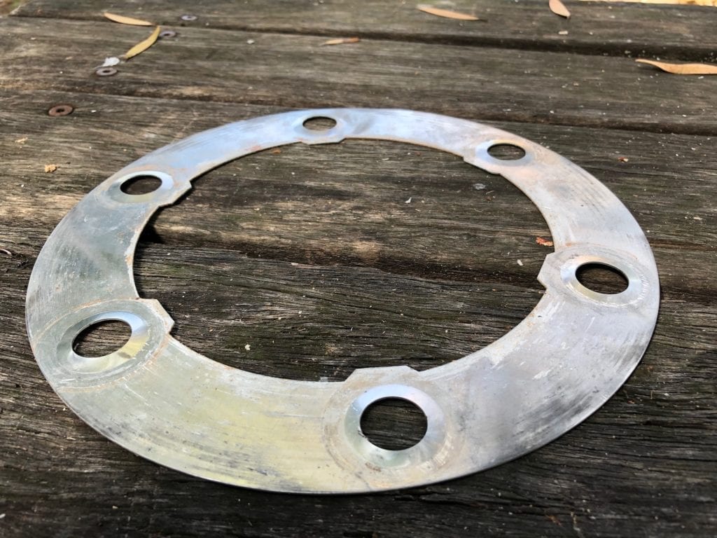 Aluminium shim with tabs removed. Will be re-used as a backing plate between hub face and alloy rims.