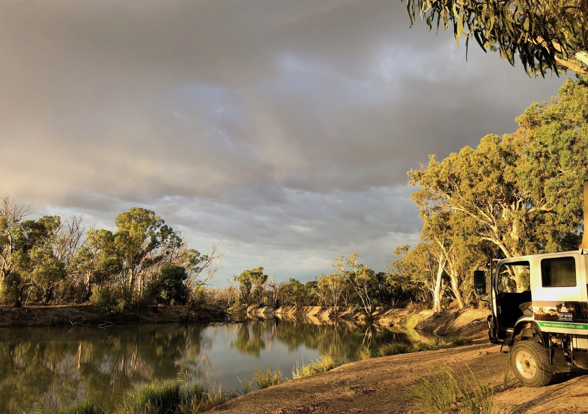 Camping On The Murray River, early morning light with dark clouds approaching.