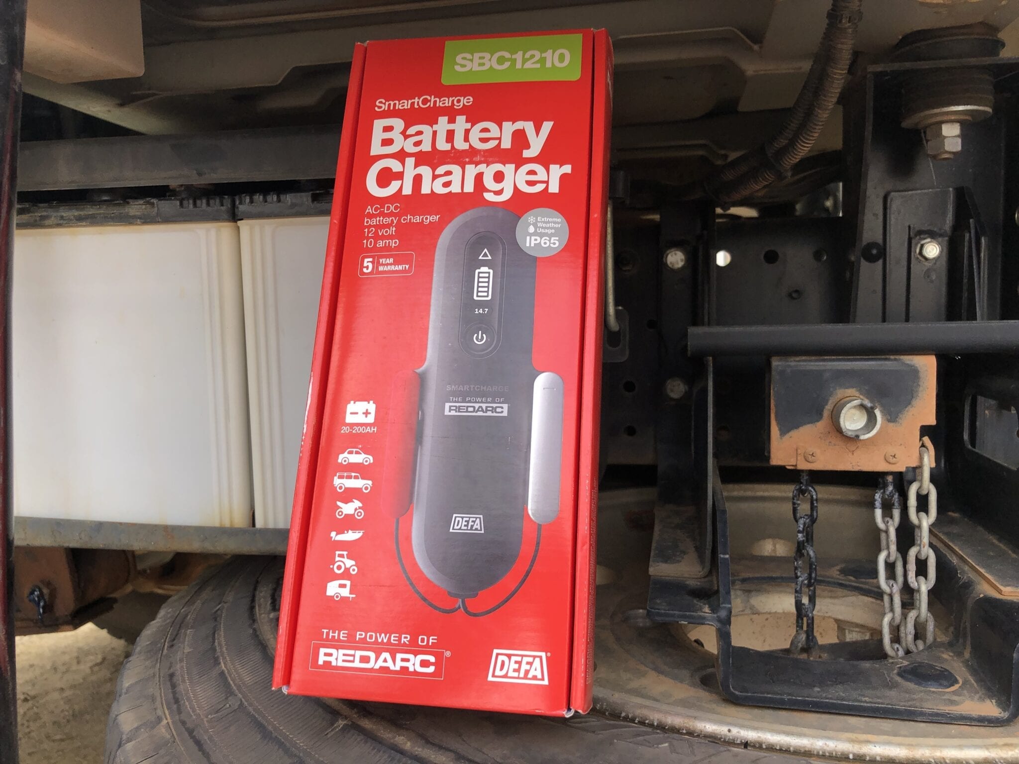 Our new REDARC battery charger pictured in front of our truck batteries.