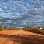 Dark clouds contrast sharply with the desert colours along the Sandover Highway, NT.