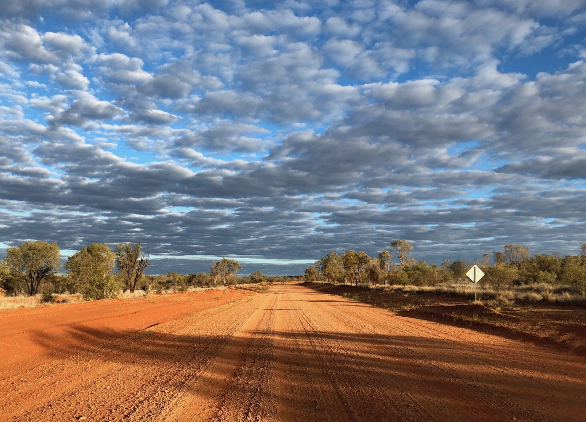 Dark clouds contrast sharply with the desert colours along the Sandover Highway, NT.