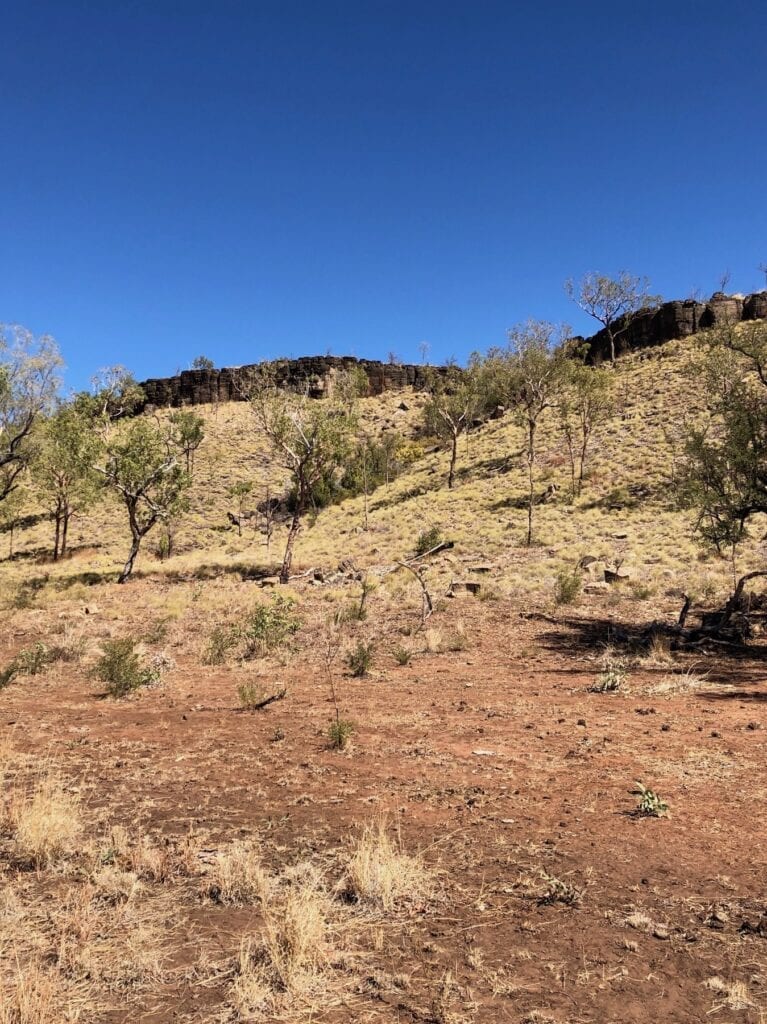 A thick layer of black rock has been exposed by erosion in an escarpment beside Gibbie Creek. Judbarra / Gregory National Park.