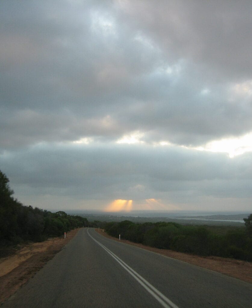 The sun blasting through the clouds over the ocean, with the township of Kalbarri just in front.