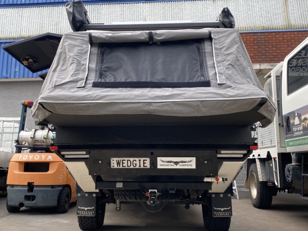 A rear view of a Wedgetail Hawk ute canopy camper, showing the innovative rear fold-down section.