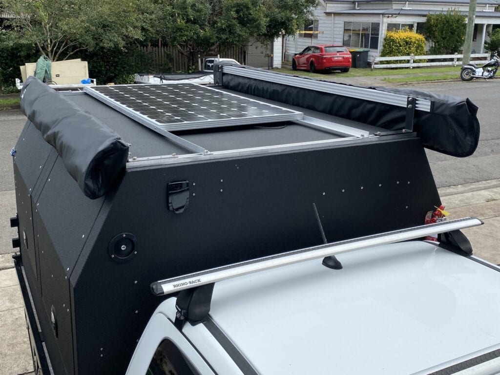 Solar panel and two awnings mounted on a Wedgetail Hawk ute canopy camper.