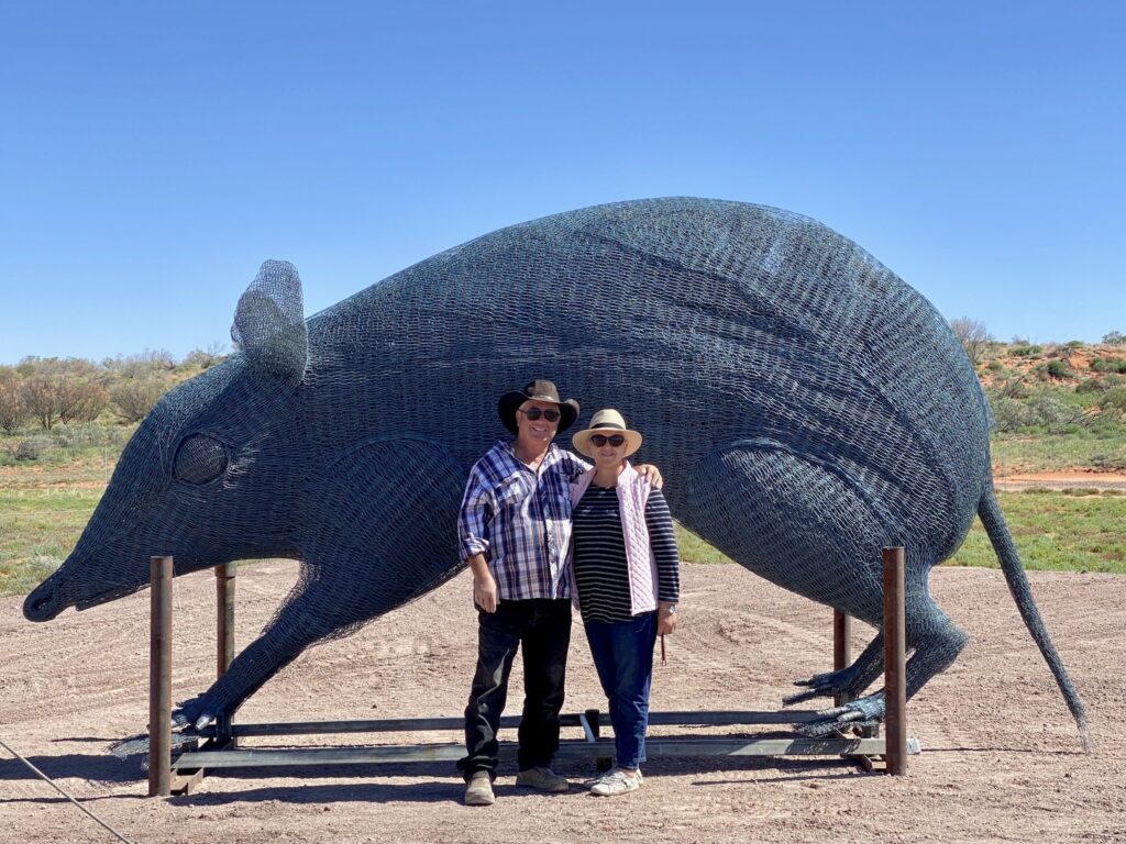 Artist Brian Campbell and wife Susan in front of Brian's bandicoot wire sculpture. Sturt National Park, NSW.