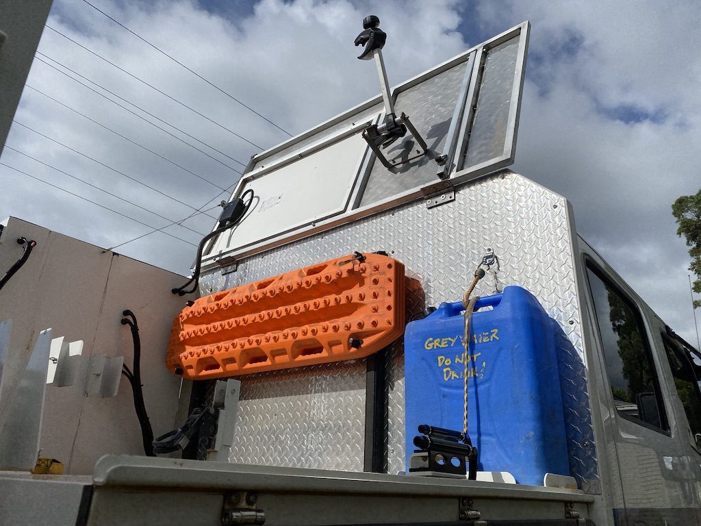 The storage area for our bikes on our Isuzu NPS crew cab, showing the top lid opened.