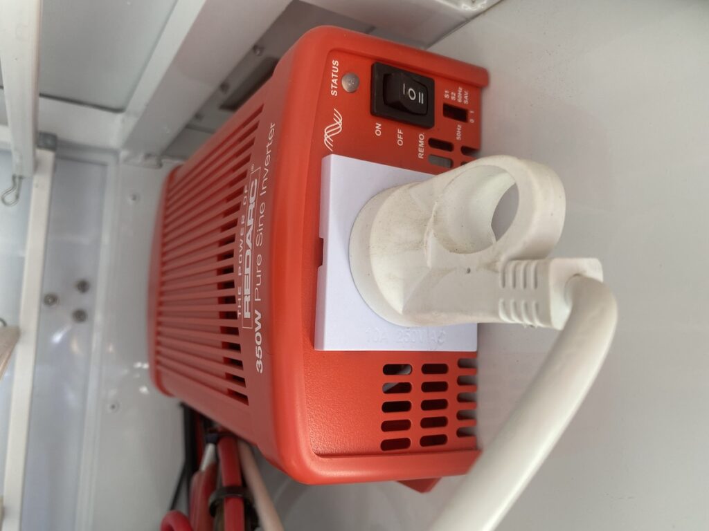 REDARC 350W inverter with power cord attached to 3 pin 240VAC plug inside camper.