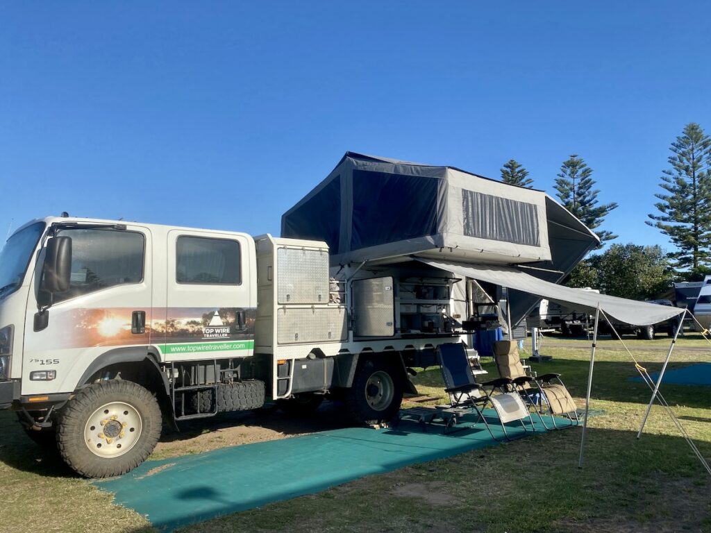 Wedgetail camper set up on Isuzu NPS truck. Camper has grey canvas.