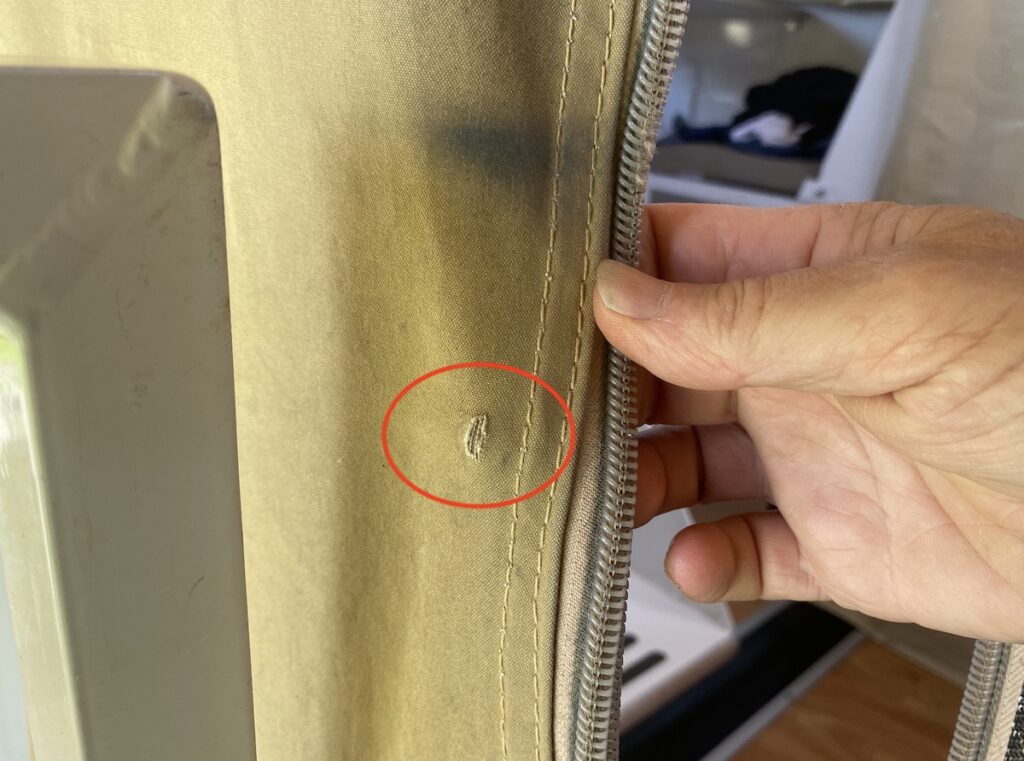 Small hole in Wedgetail Camper canvas at entry door, due to wear and tear.