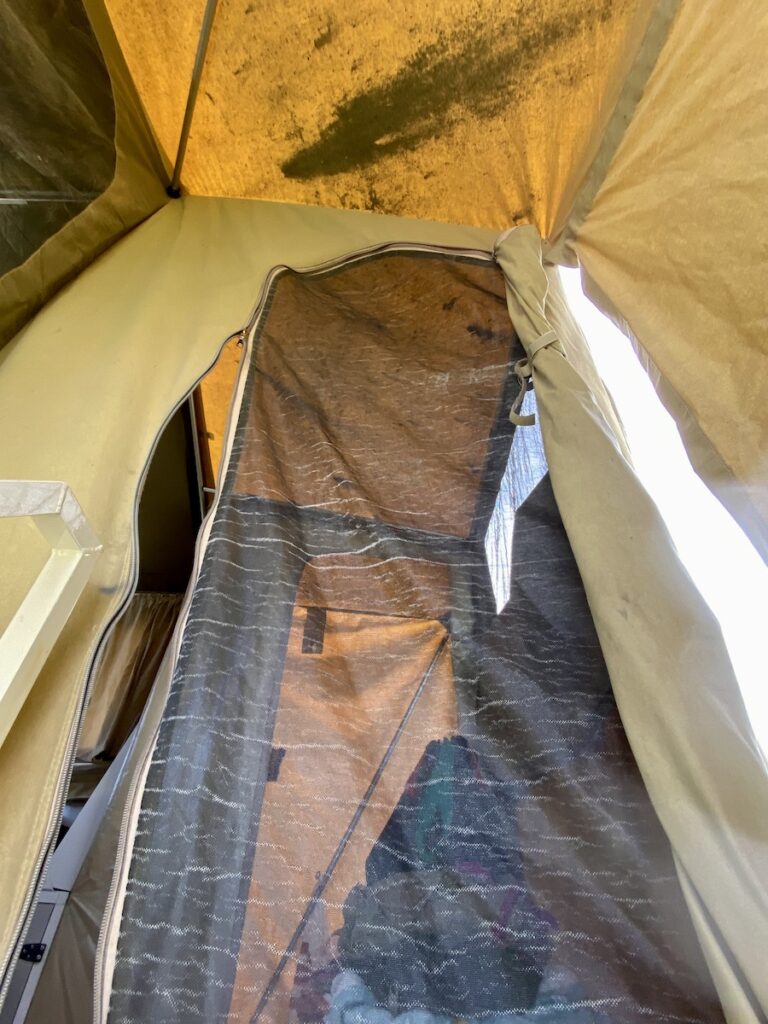 Worn screen door and stained roof on original camper canvas. Wedgetail Camper.