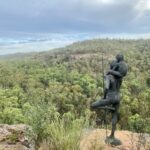 Dhayaanduul Waanda (First Lesson) sculpture. Man with son gazing over Dandry Gorge. Sculptures In The Scrub, Pilliga Forest NSW.