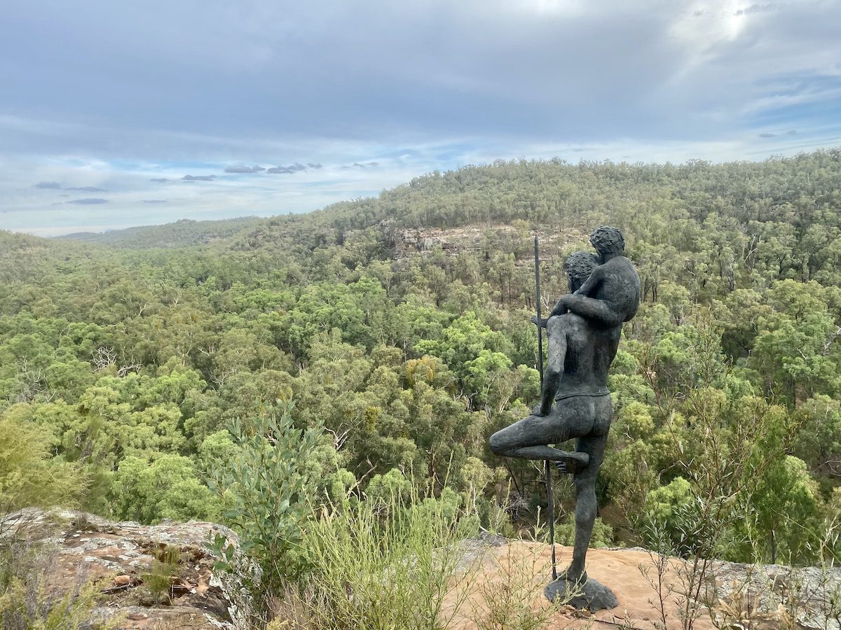 Dhayaanduul Waanda (First Lesson) sculpture. Man with son gazing over Dandry Gorge. Sculptures In The Scrub, Pilliga Forest NSW.