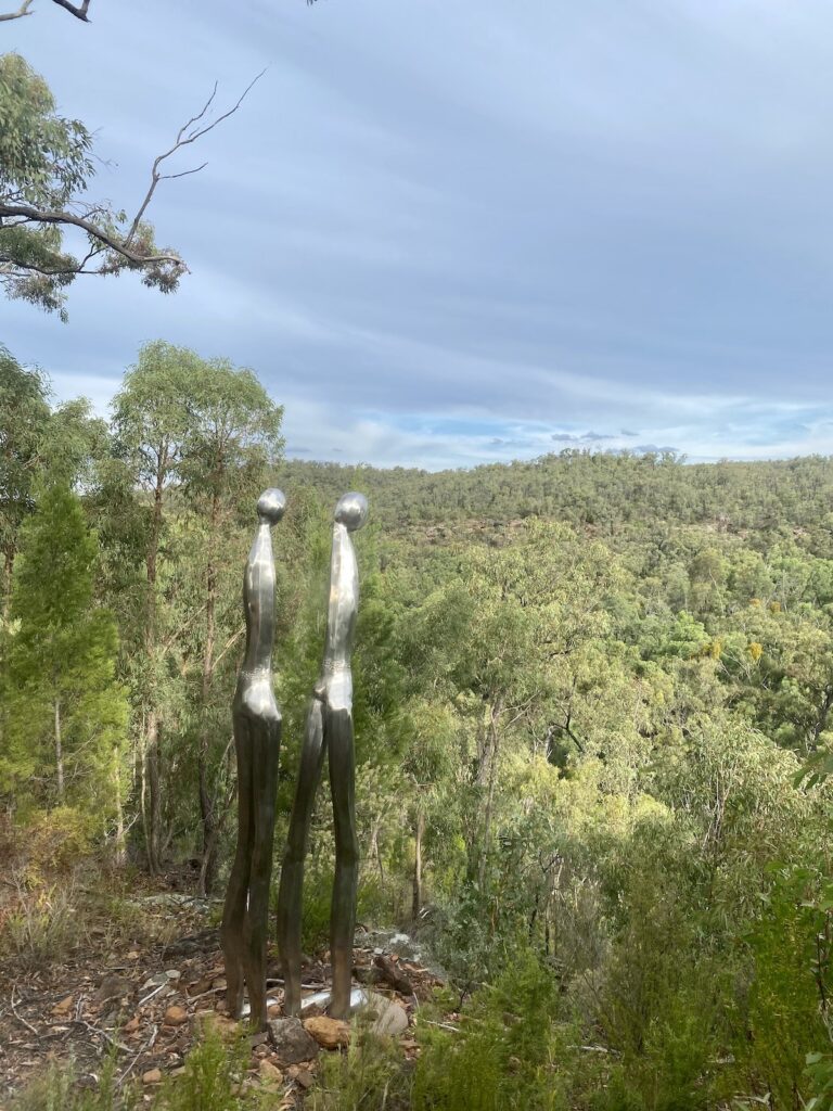 Yurrul Dwuhi (Scrub Spirits) sculpture. Two spirits standing on edge of gorge. Sculptures In The Scrub, Pilliga Forest NSW.