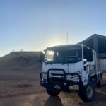 4x4 Isuzu truck with flat-topped mesa in background. On Windorah - Bedourie Road.