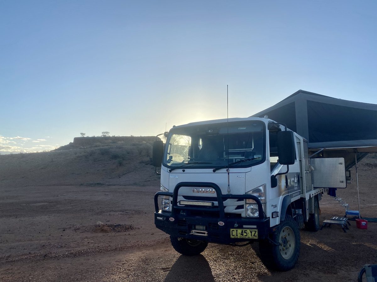 4x4 Isuzu truck with flat-topped mesa in background. On Windorah - Bedourie Road.