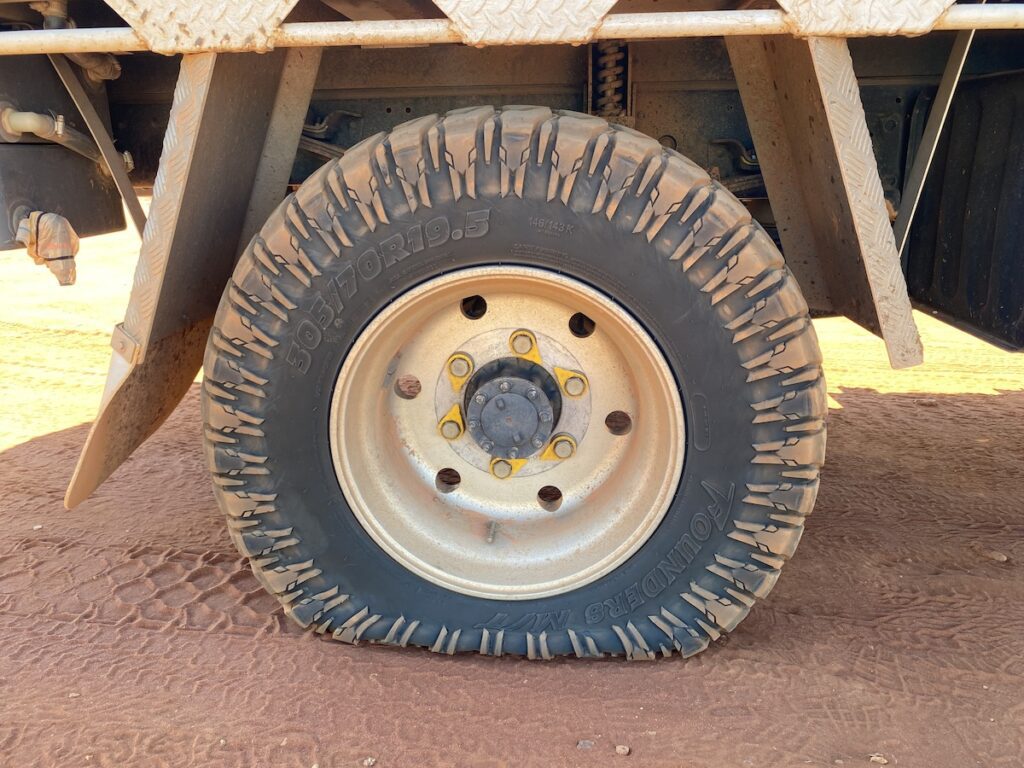 Flat rear tyre on an Isuzu NPS 4x4 truck.