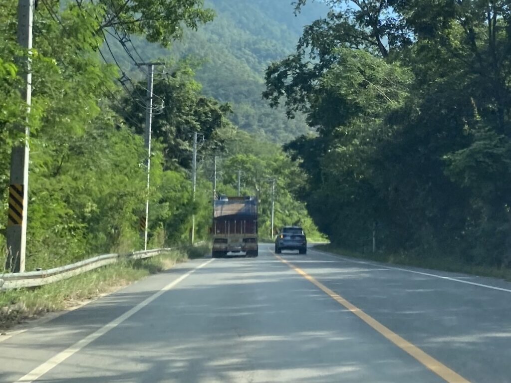 Driving in Thailand. 4WD overtaking truck on blind corner.